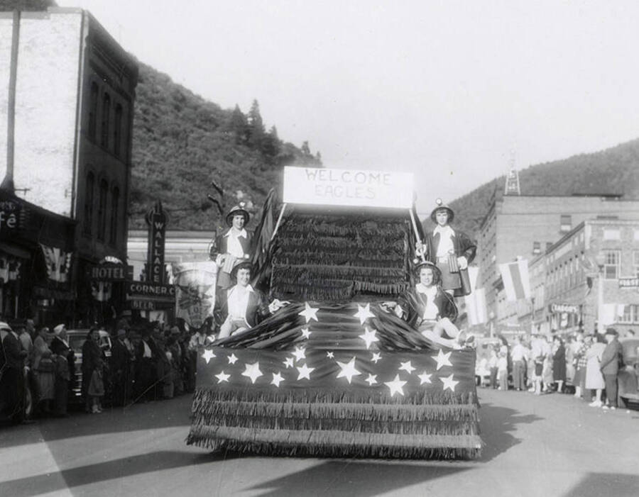 A few women riding on a float that says "Welcome Eagles" during the Eagles parade in Wallace, Idaho.