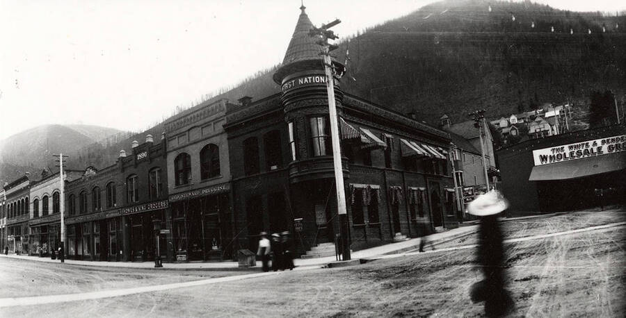 The First National Bank in Wallace, Idaho. Howes and King Grocers and George Steward Druggist can also be seen.