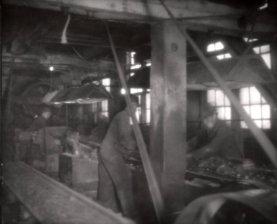 Two men working in the interior of the mills.