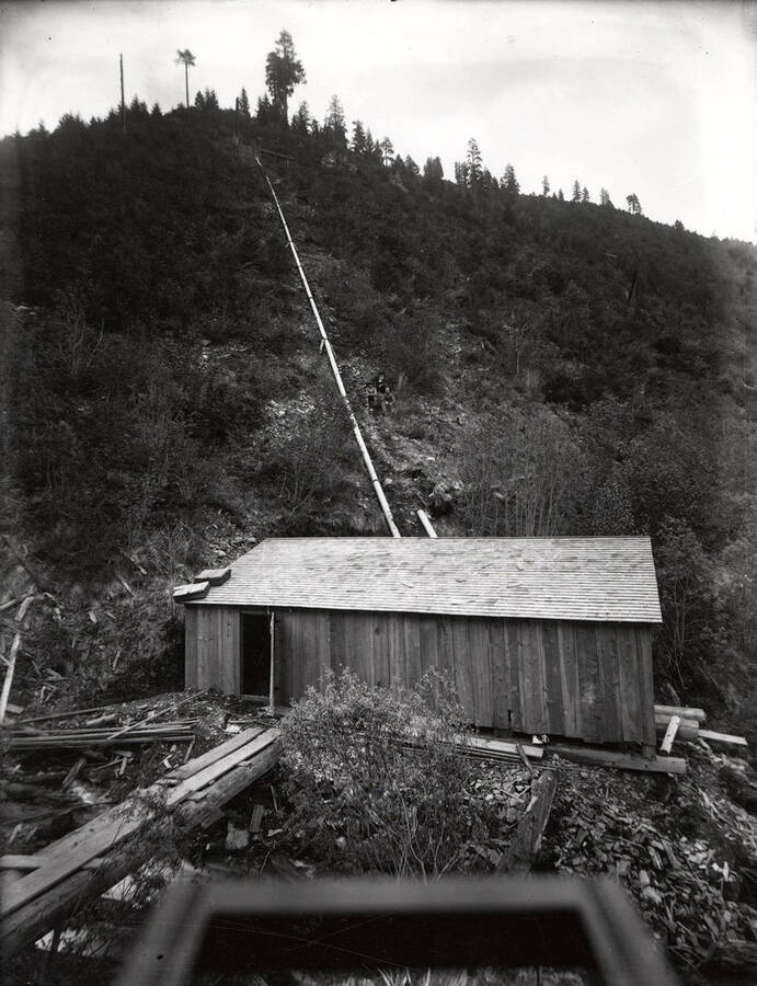 View of a mining building at the bottom of a hill.