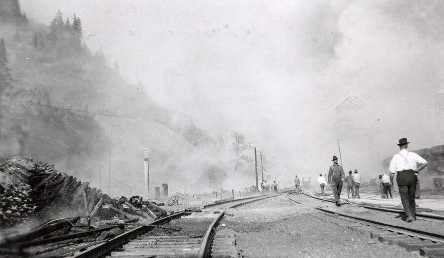 People standing by the railroad tracks during the fire in Burke, Idaho.