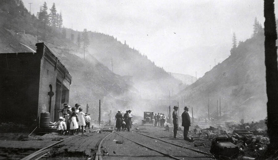 People standing by the railroad tracks during the fire in Burke, Idaho.