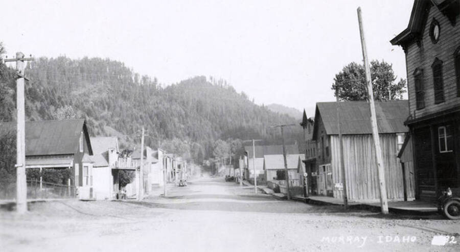 Looking down a street, lined with buildings and a hill in the distance, in Murray, Idaho.