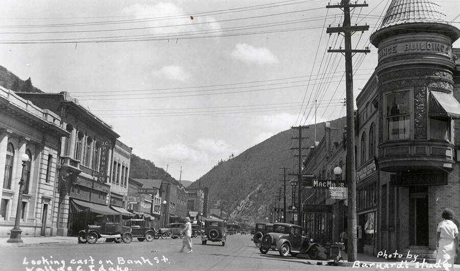 Looking east down Bank Street in Wallace, Idaho. Buildings are along the sides of the street, with cars parked out front.