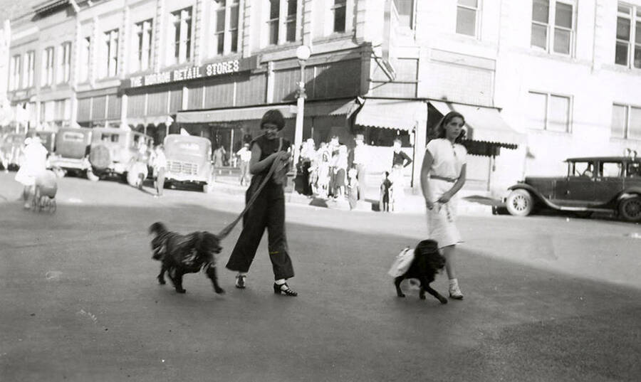 Two girls walking their dogs during the Veterans pet parade in Wallace, Idaho.