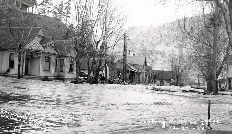Looking north on Second Street during the Placer Creek flood in Wallace, Idaho. Houses line the street.