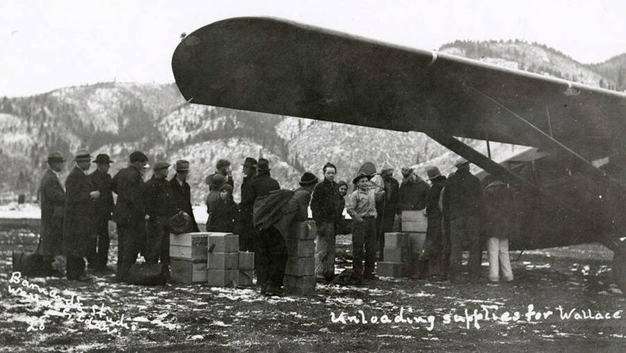 People unloading supplies from an airplane for Wallace, Idaho, during the Placer Creek flood.