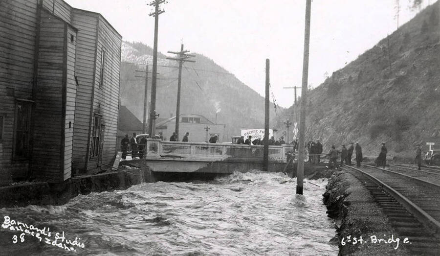 People standing on the Sixth Street bridge during the Placer Creek flood in Wallace, Idaho.