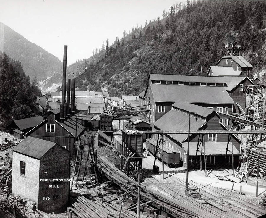 This image of the exterior of the Tiger-Poorman Mill in Burke, shows an elevated tramway and more wooden structures than a photo of the same location dated 1915.