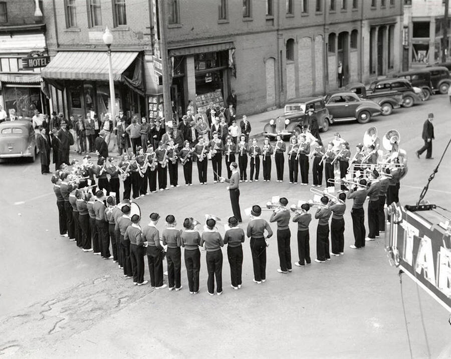 The Wallace High School Band standing in formation, with the conductor in the middle, during a parade in Wallace, Idaho.