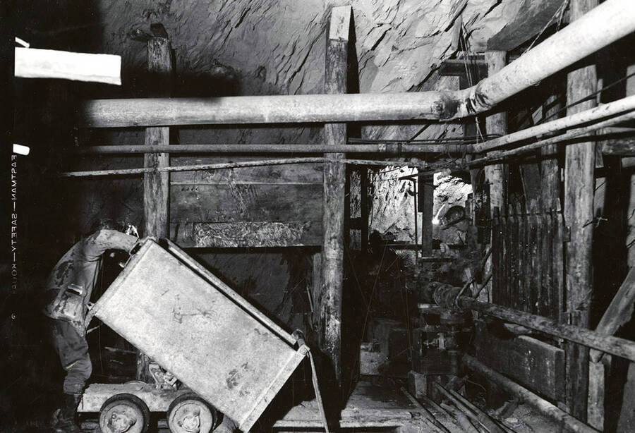 A man emptying an ore cart in the Silver Dollar Mine in Osburn, Idaho.