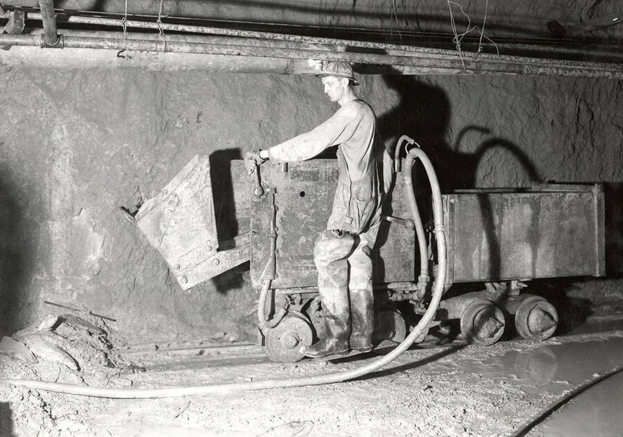 A man working underground with an ore cart in the Silver Dollar Mine in Osburn, Idaho.