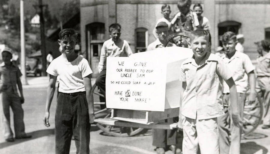 Children riding a cart, with a sign in front, in the Fourth of July Parade in Wallace, Idaho.