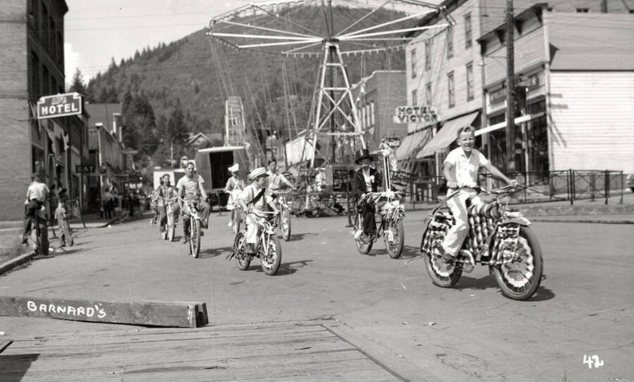Children, who are in costume, riding bicycles in the Mullan 49'er parade in Mullan, Idaho.