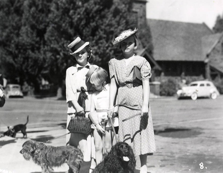 Three girl, who are in costume, standing with their dogs during the Wallace pet parade in Wallace, Idaho.