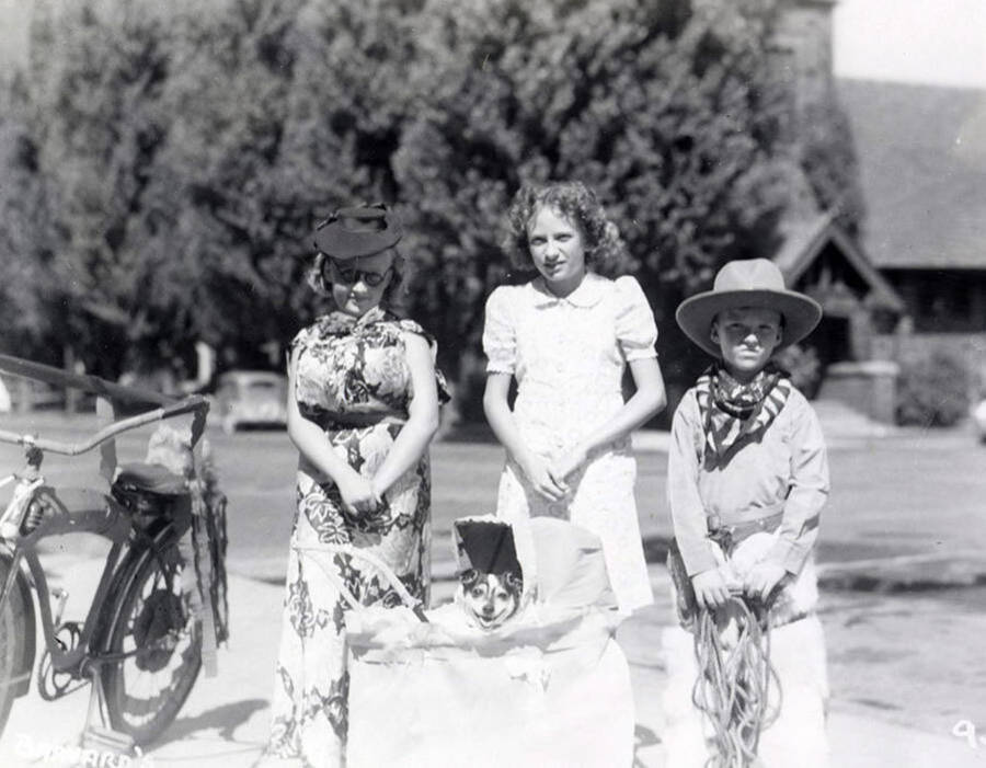 Three children, who are in costume, standing with their dogs, who is in a stroller, during the Wallace pet parade in Wallace, Idaho.