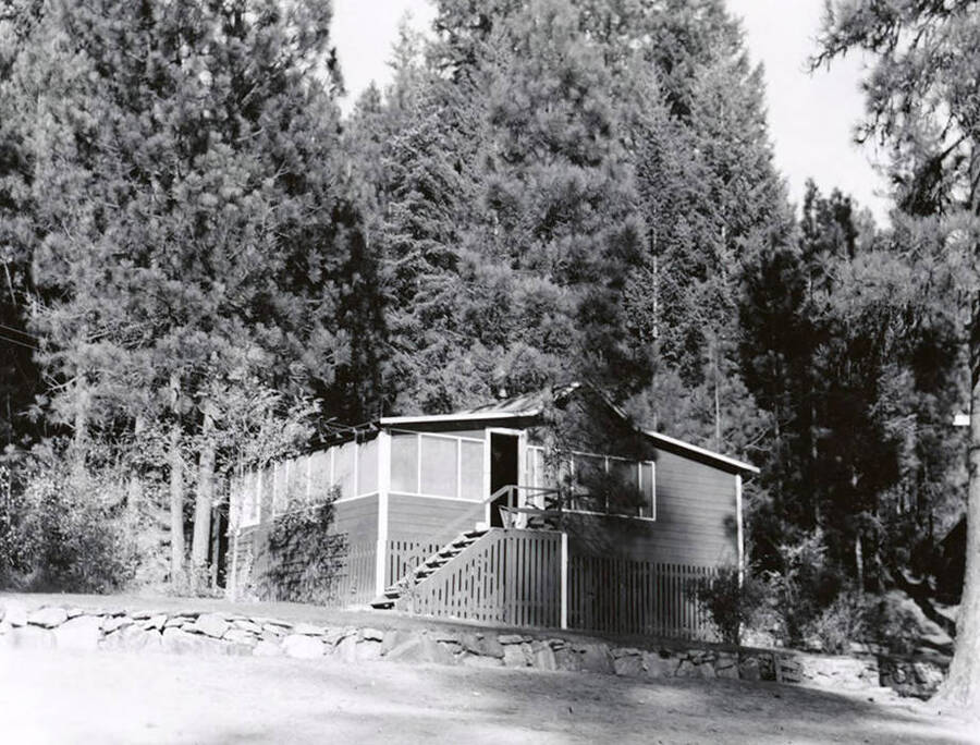 Exterior view of the Mortimer home on Coeur d'Alene Lake. The house is surrounded by trees.