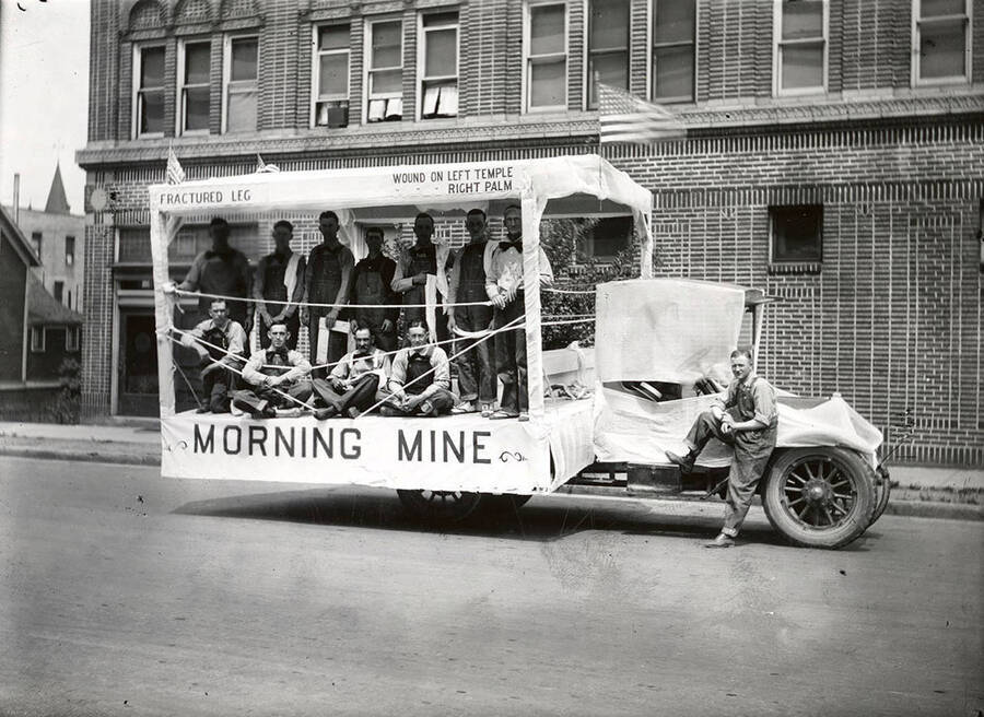 A group of men standing and sitting on the Morning Mine float in the Fourth of July Parade in Wallace, Idaho.