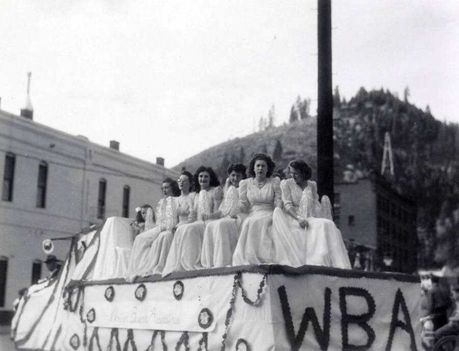 A group of women sitting on a float being driven in the Elks Roundup parade in Wallace, Idaho.
