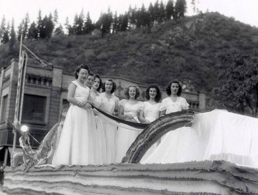 A group of women standing on a float being driven in the Elks Roundup parade in Wallace, Idaho.