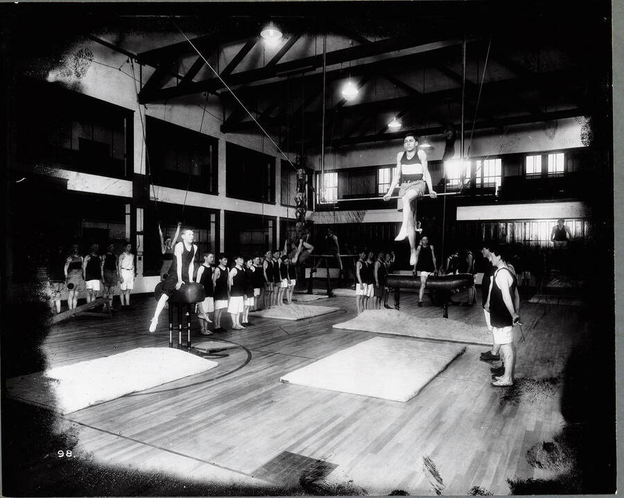 Interior view of the Wallace High School Gymnasium, May 27, 1915. Students are pictured using various gymnastic equipment.