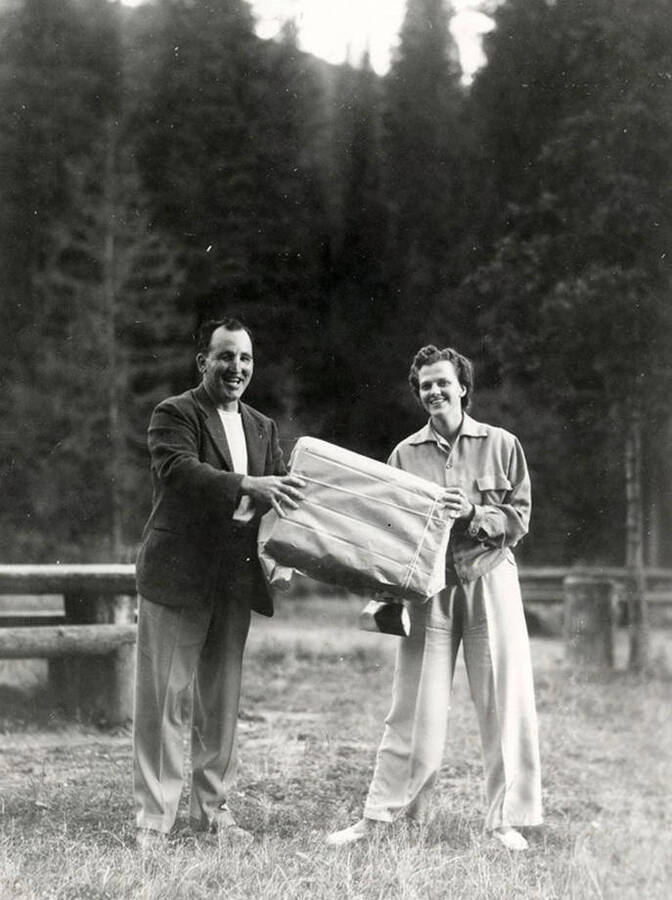 Two people standing together, holding a package during Wallace Jaycee's picnic in Pottsville, Idaho.