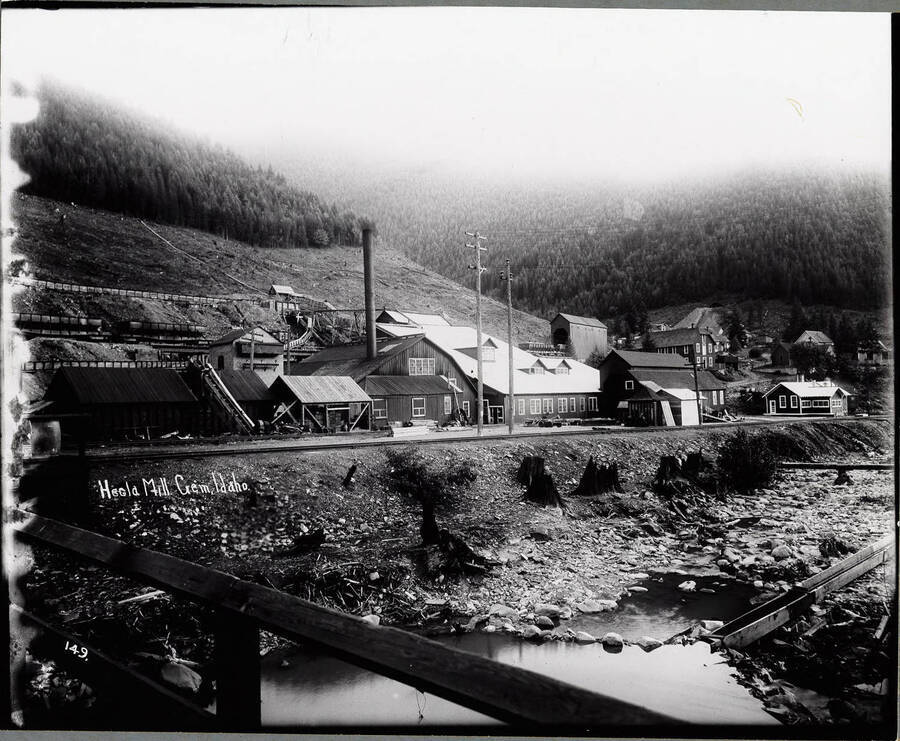 Exterior view of Hecla Mill in Gem, Idaho, showing several wooden structures; Caption on front: "Hecla Mill. Gem, Idaho."