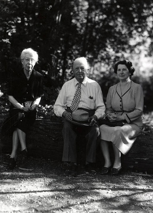 Nellie Stockbridge (on left) sitting on a log next to a man and a women during the Heilbronner Family Missoula trip.