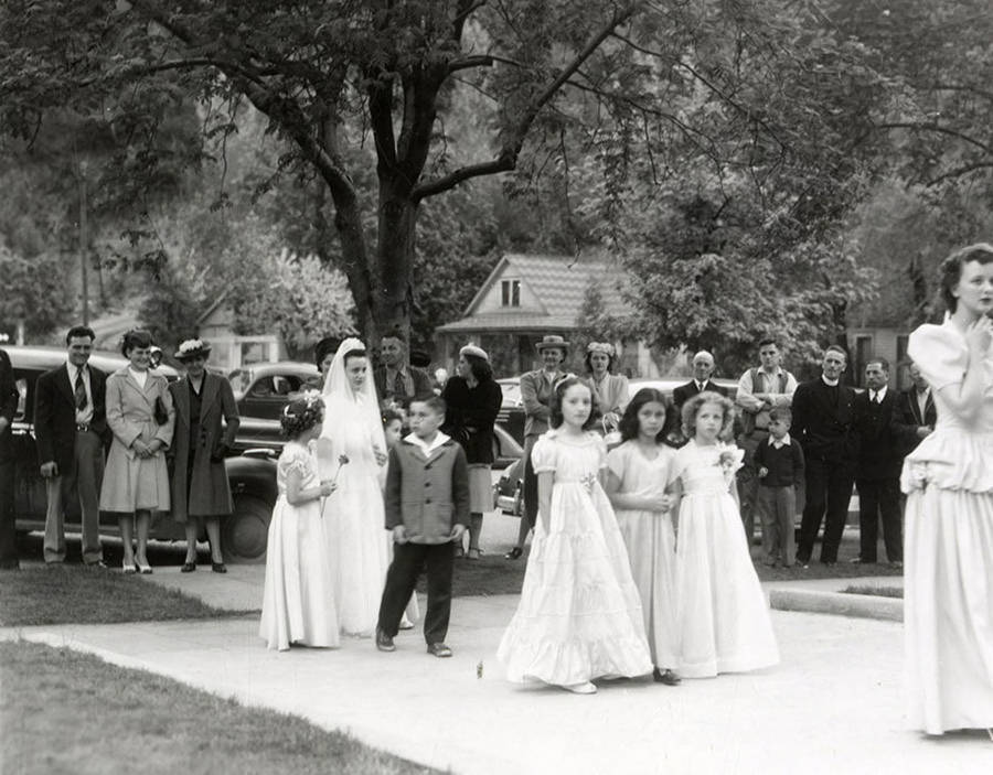 A group of people marching from the Our Lady of Lourdes Academy to the Church during the Blessed Virgin procession in Wallace, Idaho.