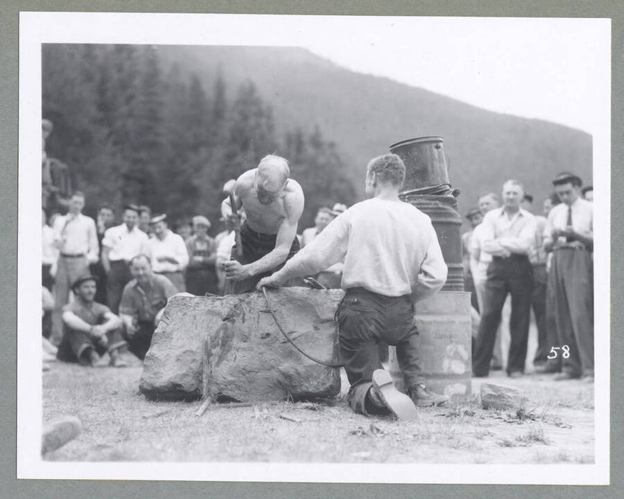A crowd watches on as men compete in an ore car loading contest during the Mullan '49'er Parade.