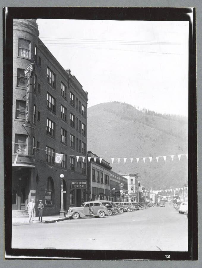 A string of pennant flags across Cedar Street in Wallace, Idaho, with the historic Samuel's Hotel visible on the left.