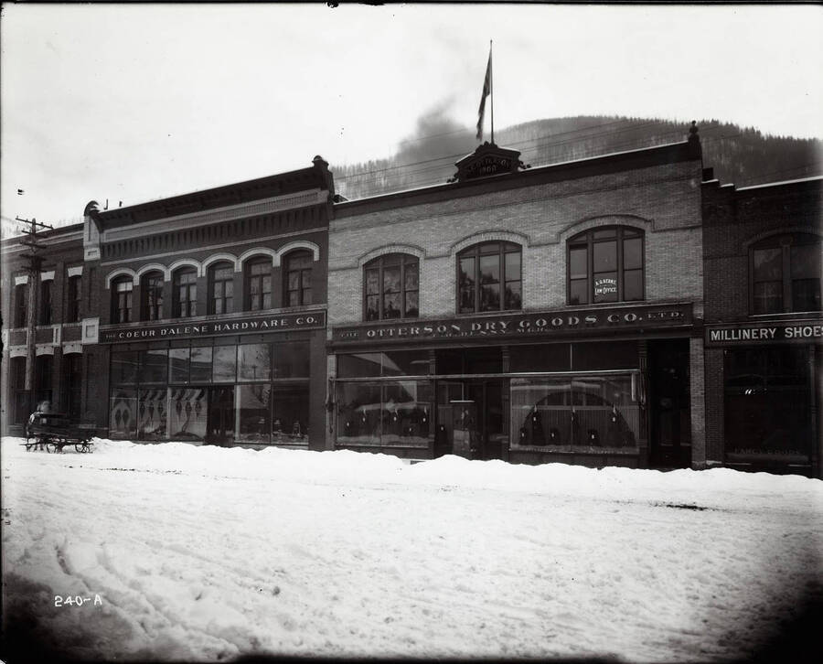 Exterior image of the Coeur d'Alene Hardware Co. and the Otterson Dry Goods Co. A.G. Kern's Law office is upstairs in the Otterson Building. Snow shoes can be seen in the hardware store's window display.