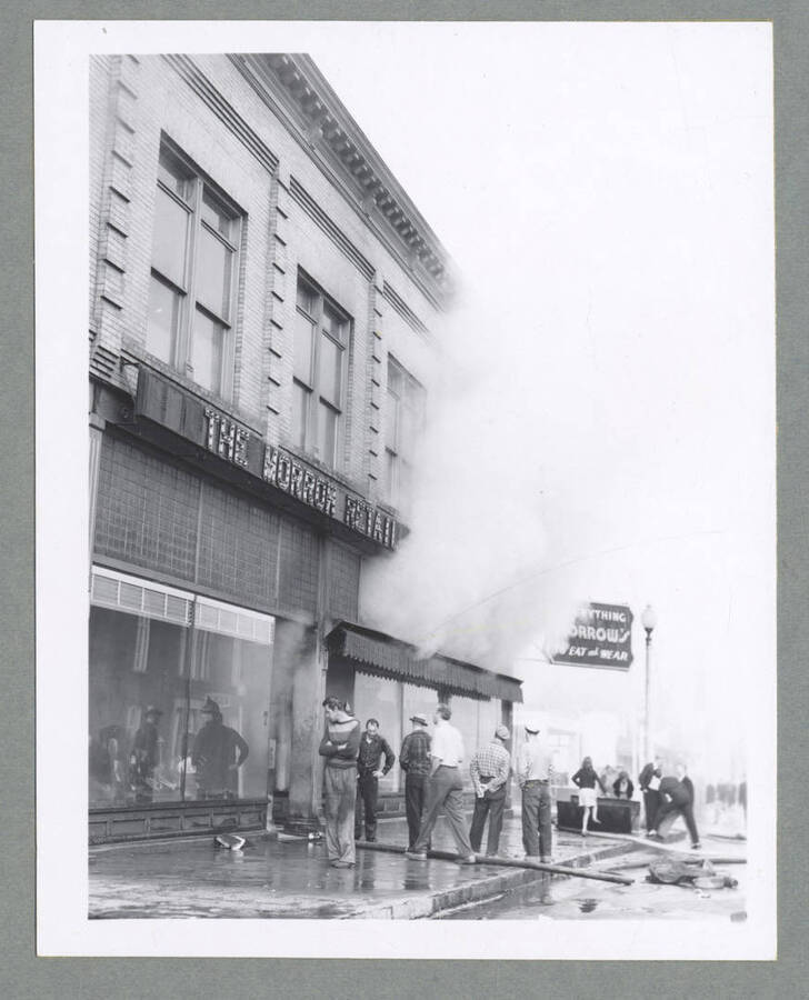 People standing outside of the Morrow Retail Store in Wallace, Idaho, as it burns.