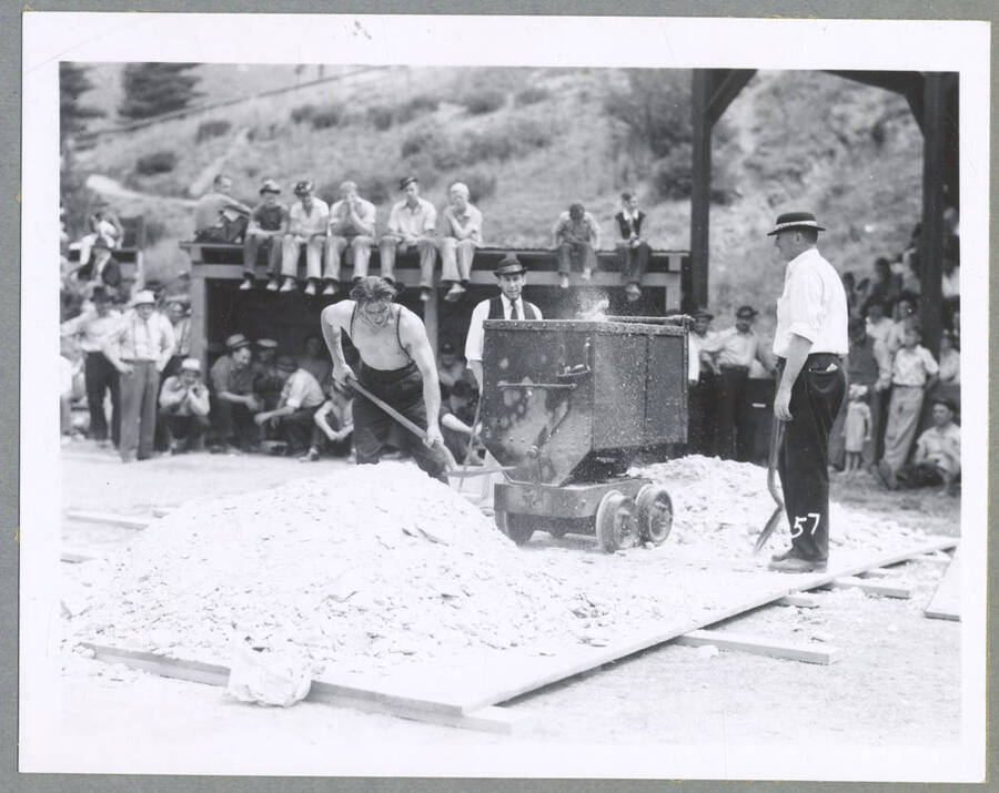 Men watching a motorcycle being pushed up a hill during the Mullan '49'er Parade.
