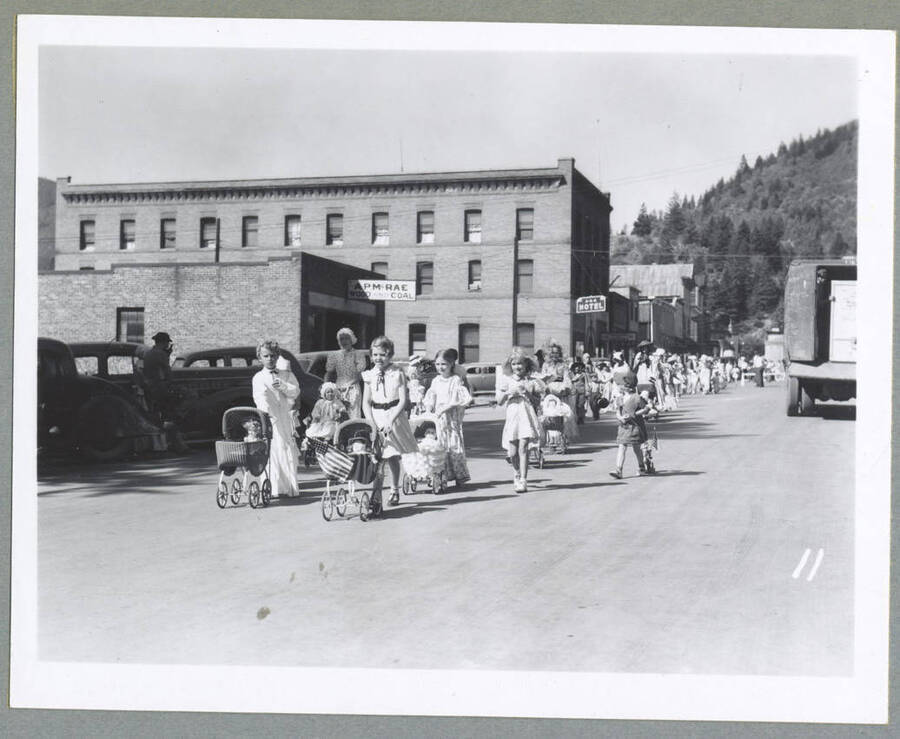 Children's Parade in Mullan, Idaho, with children wearing costumes, riding bikes and wagons.