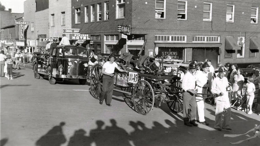 Firemen pulling a wagon in front of a fire engine during the 49'er Parade in Mullen, Idaho.