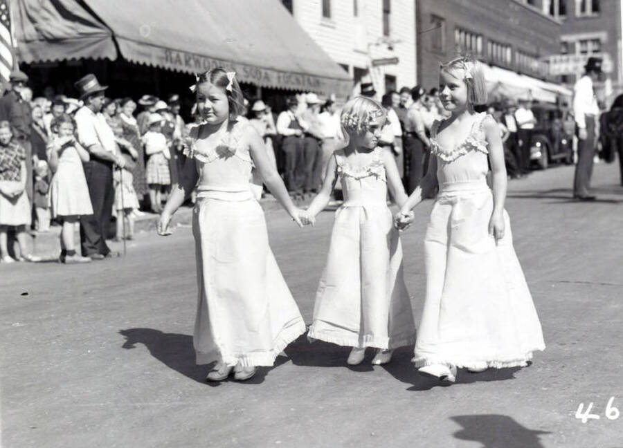 Three young girls in costume marching along during the 49'er Parade in Mullan, Idaho.