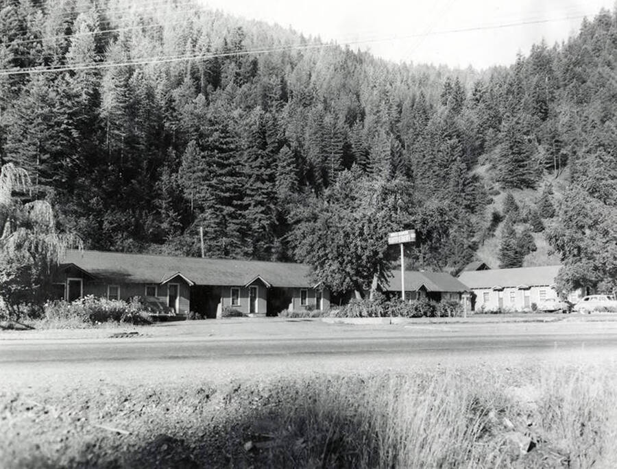 View of Wines Modern Auto Court in Wallace, Idaho. This building is located on Osburn Road and is surrounded by trees.