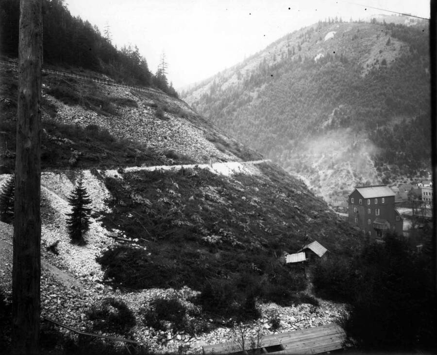 Exterior view of Marsh Mine showing a hillside with buildings at the base. Note wooden flume near top of hill. Taken Sept. 28, 1910.