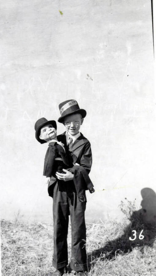 A child in costume holding a dummy doll during the 49'er Parade in Mullan, Idaho.