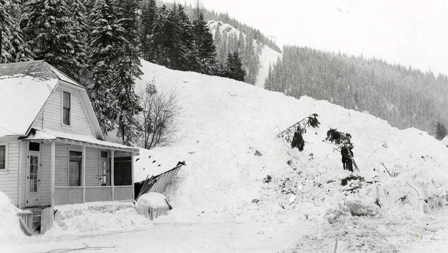 People working on digging out the road by their home in historical Yellow Dog, Idaho, after a major snow slide.