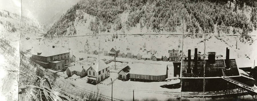 View of Mace, Idaho covered in snow during the winter. The railroad station can be seen on the left.