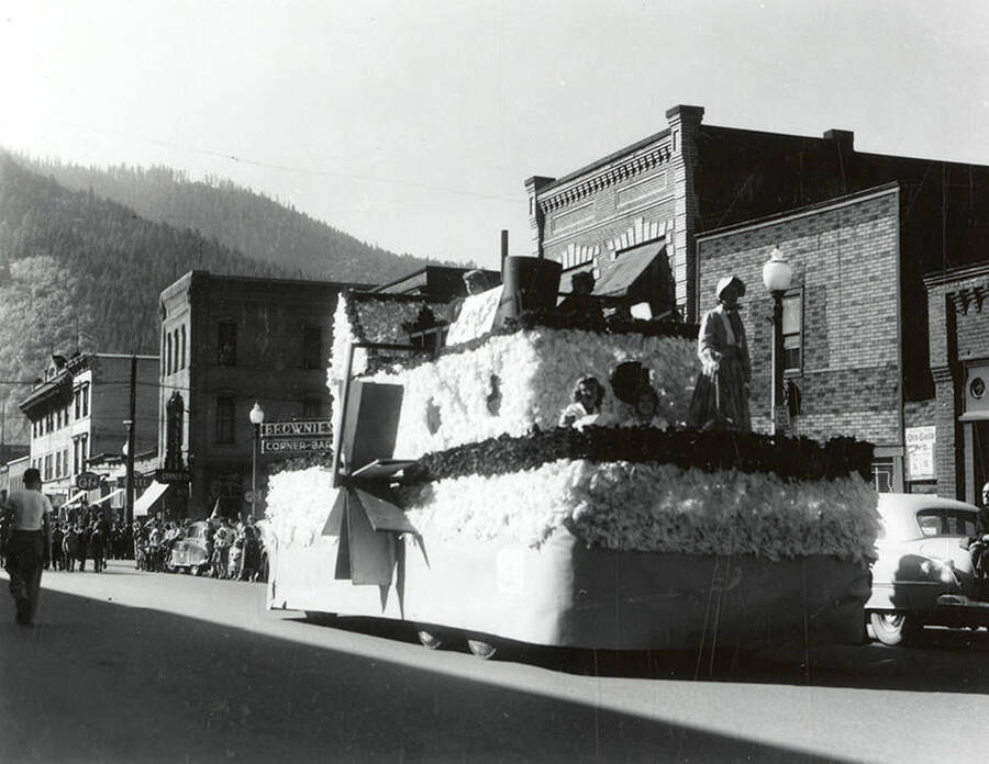 Women in costume riding atop a float decorated like a paddle steamer during the Elks Parade in Wallace, Idaho.