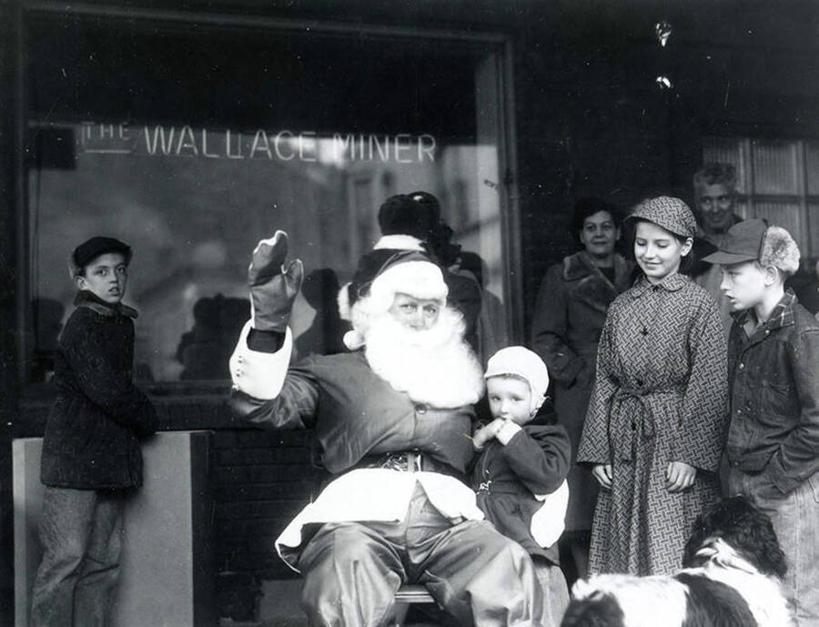 Santa Claus sitting with children in front of the Wallace Miner window.