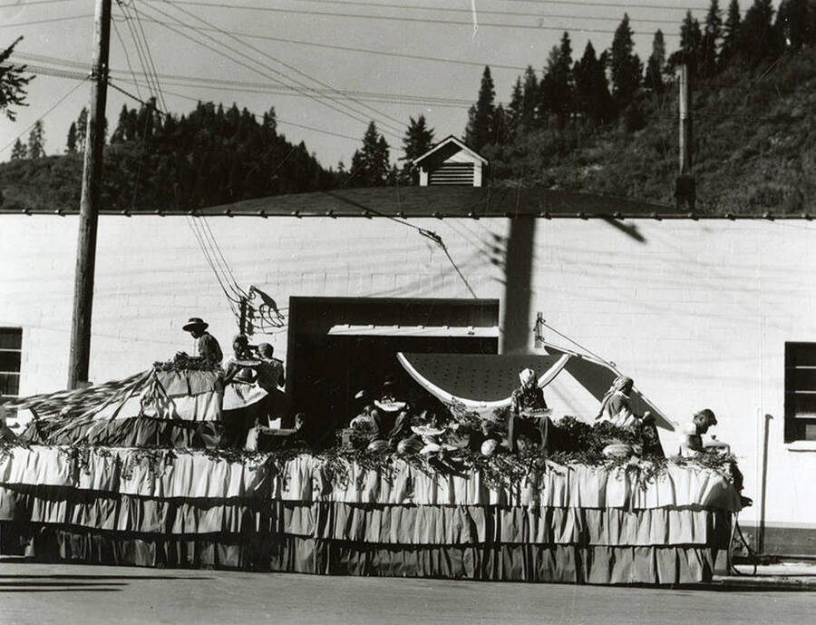Several people in blackface eating watermelon on top of a large float during the Elks Parade in Wallace, Idaho.
