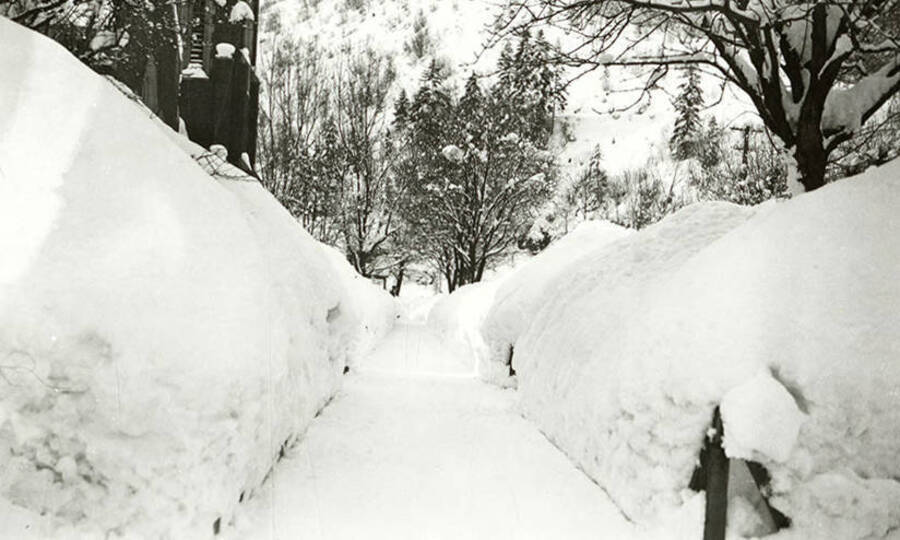 Larges walls of plowed snow lining the sidewalk on Pine Street in Wallace, Idaho.