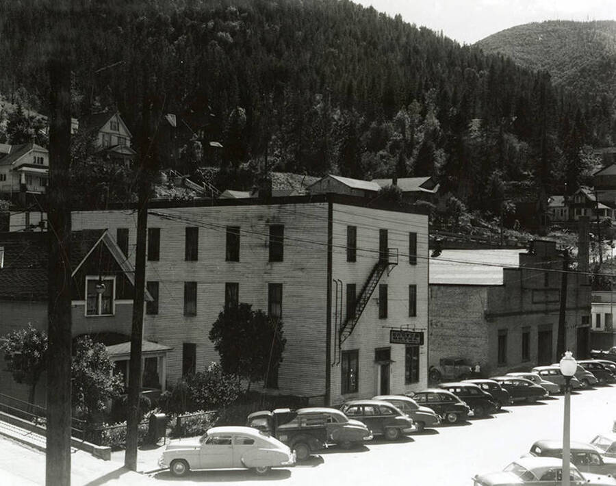 View of the Carter Hotel in Wallace, Idaho. Cars can be seen parked out front. The hotel is located on the southwest corner of Hotel Street and 7th Street.
