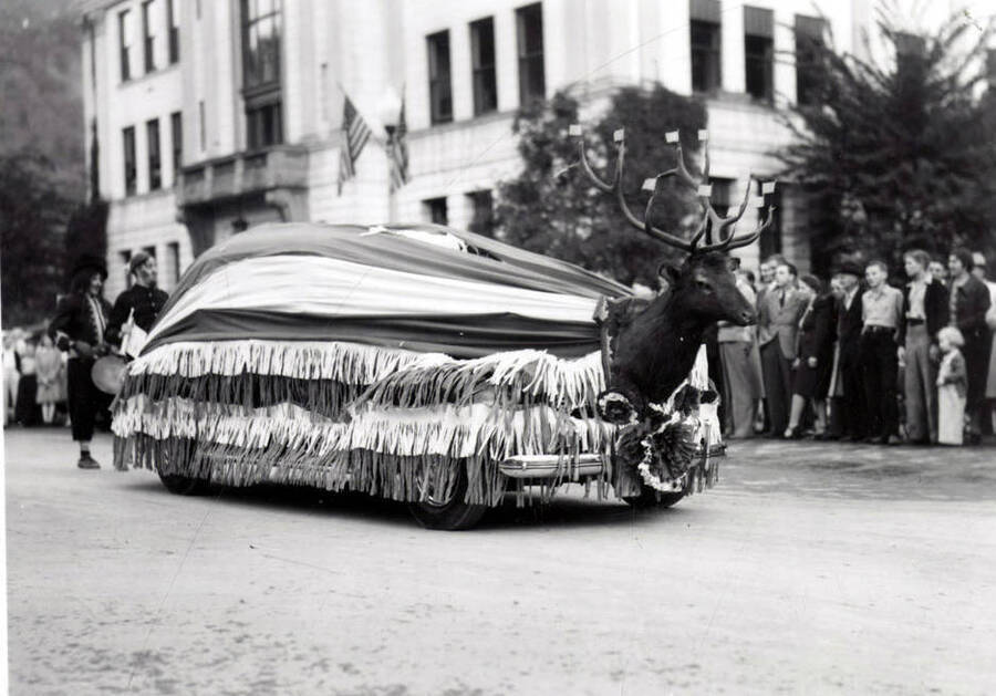 A car covered in a large American flag with an elk head mounted on the front during the Elks Roundup Parade in Wallace, Idaho.