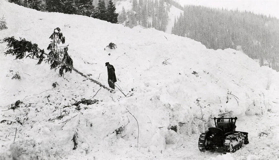 A man taking a break from working on digging out the road by his home in historical Yellow Dog, Idaho, after a major snow slide.