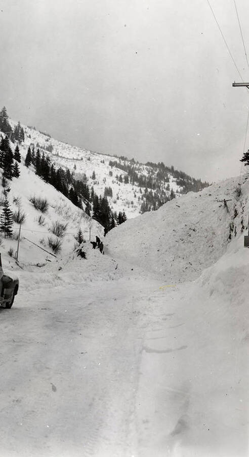 People walking atop the snow slide in historical Yellow Dog, Idaho.